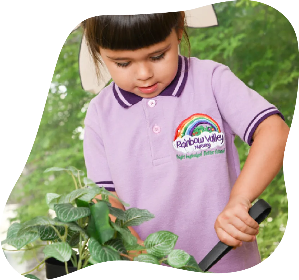 Child in nursery uniform exploring plants outdoors