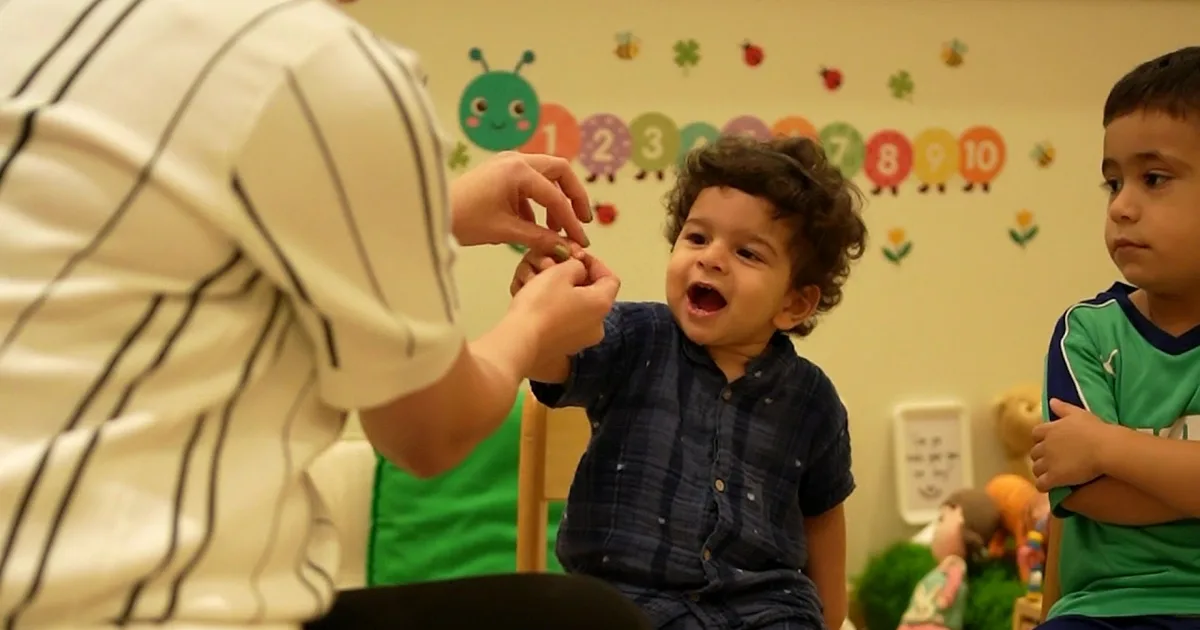 A Rainbow Valley Nursery teacher playing with a toddler in the classroom