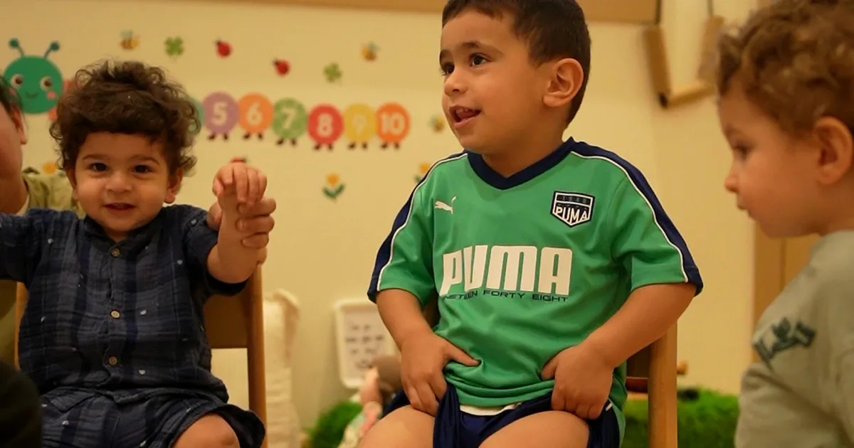 Children sitting together and smiling in a Rainbow Valley Nursery classroom